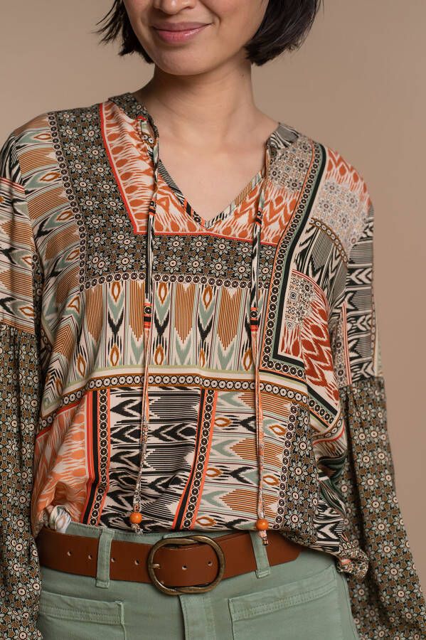 Geisha • rechte, loose fit valling • recht kraagje met sierkoordjes met kwastjes die zowel los als vast gedragen kunnen worden • lange mouwen met elastieken cuffs • lage mouwinzet waardoor een pofeffect ontstaat • valt over de heup • lengte 65cm(vanaf